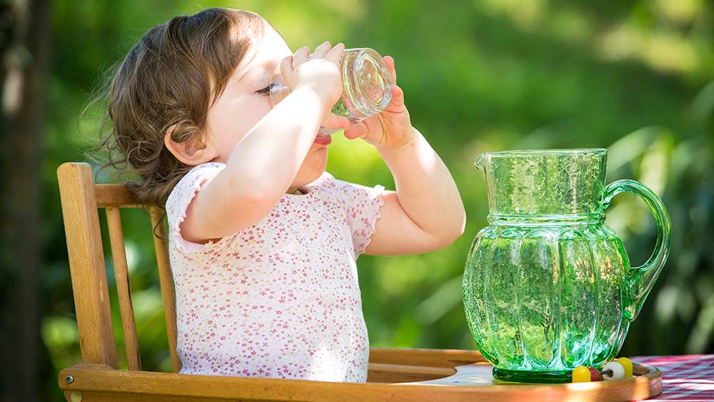 A child drinking tap water on her high chair