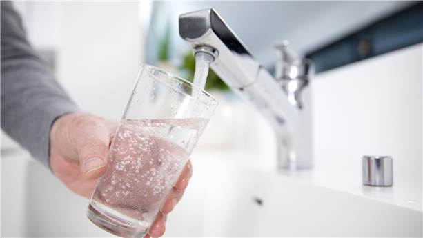 Person filling a glass of water